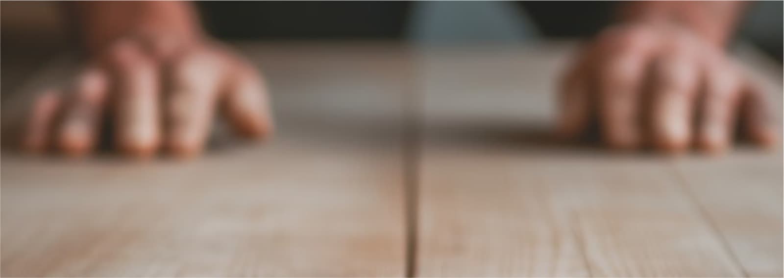 Hands working on wooden surface